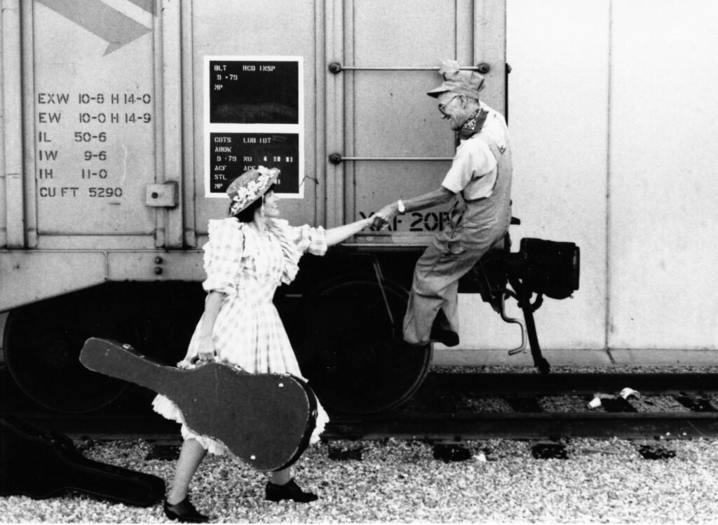 Otis Roy and Penelope, Musical partners catching a ride in box car. Penelope has her guitar.